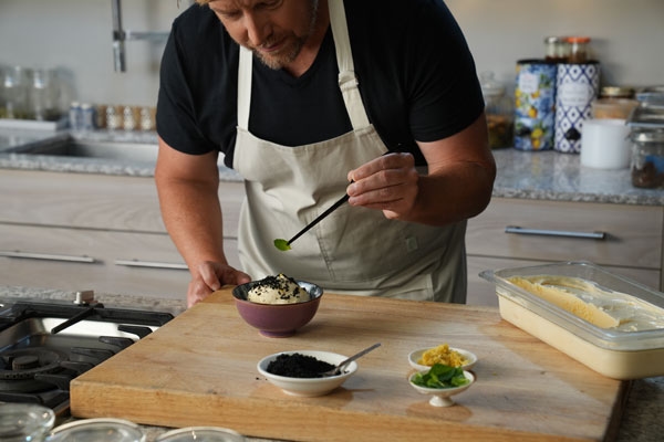 Bug Bites - Chef Richard Blais garnishing vanilla ice cream with black ants and citrus zest