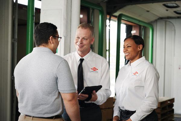 Two Orkin Pros talking to a customer-600x400