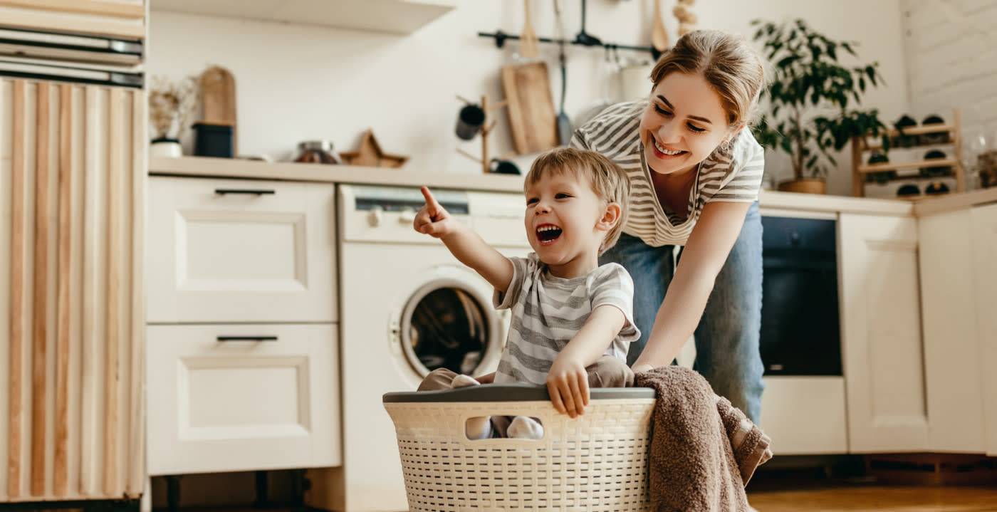 Child pushed in basket in clean kitchen
