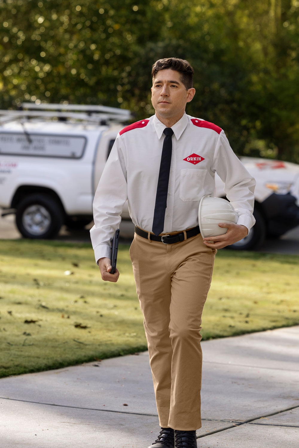 An Orkin Pro leaving his Orkin truck and walking up a customer's driveway