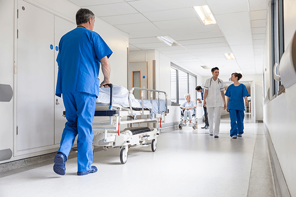 Medical worker pushing an empty gurney