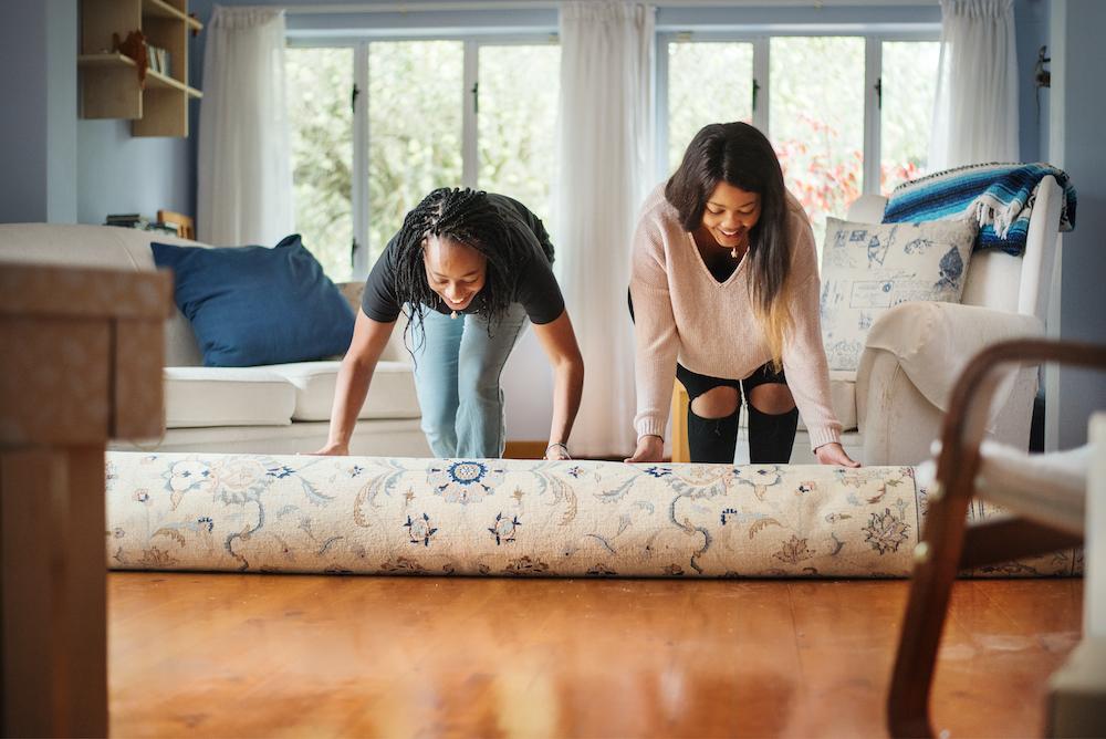 Women unrolling rug