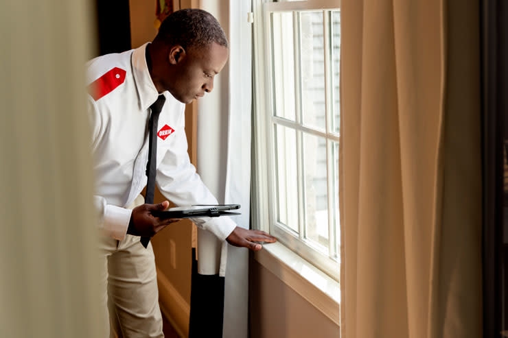 An Orkin Pro inspecting the windows in a customer's home